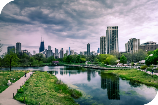 A view of the cityscape, with towering buildings, a winding river, and lush green trees